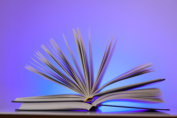 Open book on a bright blue background.Learning and knowledge symbol.Reading and education. 