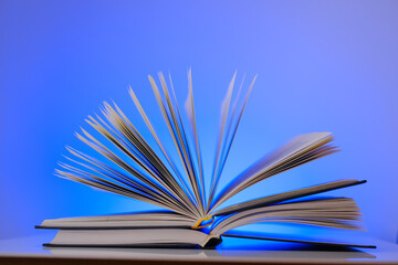 Reading books.Open book on a bright blue background.Learning and knowledge symbol.Reading and education. 