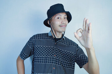 asian man ok pose. asian man with bucket hat ok pose
