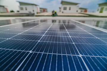 Fototapeta premium A close up of solar panels with a worker blurred in the background. The focus on the panels emphasizes the importance of renewable energy technology and solar power installations.