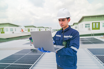 A worker in protective gear uses a laptop while inspecting solar panels on a rooftop. The image emphasizes the use of technology in managing renewable energy systems and solar power installations.