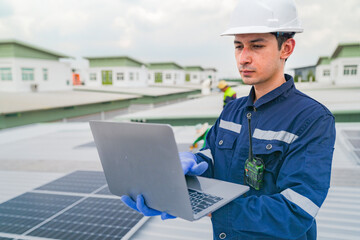 A worker in protective gear uses a laptop while inspecting solar panels on a rooftop. The image emphasizes the use of technology in managing renewable energy systems and solar power installations.