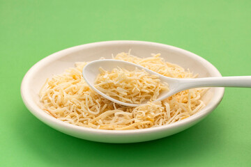 Grated coconut with dehydrated sugar in the bowl and spoon - Cocos nucifera.