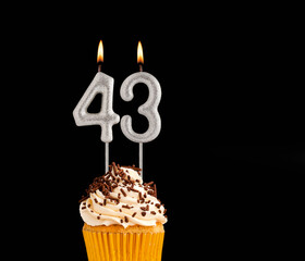 Number 43 shaped candles - Birthday cupcake on black background.