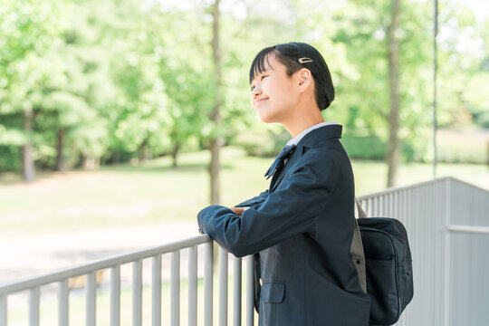 校舎の廊下にいる制服姿の中学生・高校生の女の子
