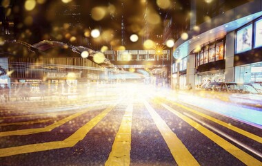 A busy street in Hong Kong at night with blurred lights and a yellow crosswalk in the foreground.