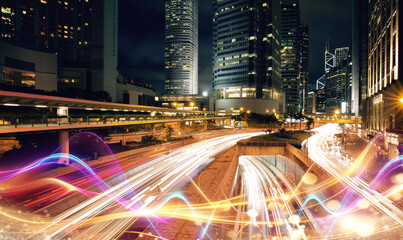 Nighttime view of a busy Hong Kong street with skyscrapers and blurred lights from traffic.