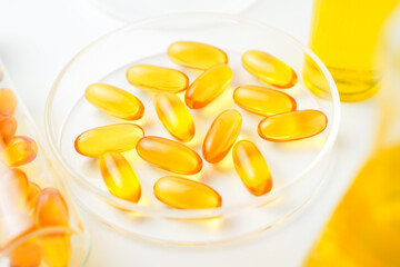 Petri dish with fish oil capsules inside, vitamin D, omega softgels, supplements, keto diet.