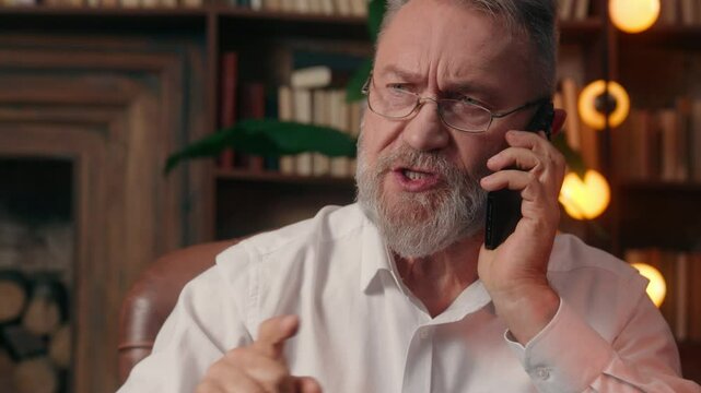 Serious Caucasian old man businessman director chief shout call mobile phone smartphone employee subordinate worker loss problem business anger boss bankruptcy failure leader ceo scold mature indoor