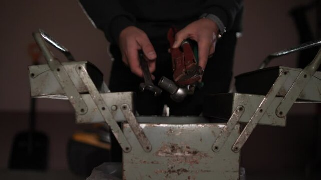 a close-up of male hands holding tools. tools from a toolbox