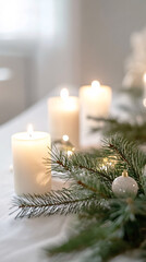 white candles and evergreen branches on a white tabletop