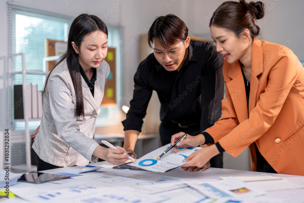 Wall mural young asian business team analyzing financial data in modern office