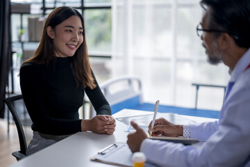 Young woman smiling while talking to doctor taking notes