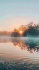 Obraz premium A serene sunrise over a misty lake with calm waters reflecting warm light and silhouettes of trees