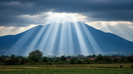 Fototapeta premium Sunbeams through clouds over mountains.