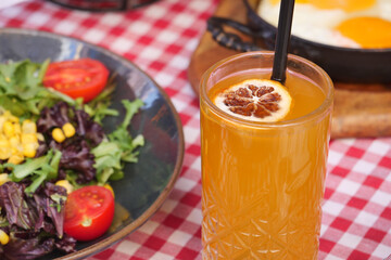 A Refreshing and Invigorating Drink Accompanied by Salad and Eggs on a Checkered Tabletop