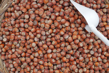 A Basket Filled with Raw Hazelnuts and an Accompanying Scoop for Easy Serving and Enjoyment