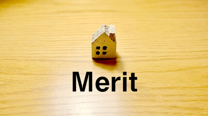 スポットライトの当たったテーブルにポツンと置いた家小物とMerit文字