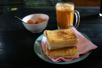 Kaya toast butter with teh tarik and half boiled eggs. Popular in Malaysia and Singapore.
