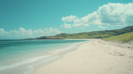 Fototapeta premium A picturesque, secluded beach with white sand, turquoise water, and lush green hills in the background under a clear blue sky with fluffy white clouds.