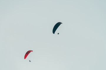 Paragliders far in the sky with clouds