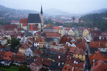 Hermoso paisaje lluvioso de las fachadas de casas, edificios, y torre una nublada mañana en Cesky Krumlov