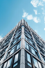 Fototapeta premium Looking up at a modern high-rise residential building facade in triangular design