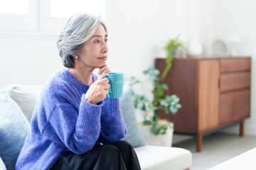 リビングでテレビを鑑賞するグレイヘアの女性