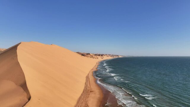 Aerial drone view of the Namib dunes close to the ocean shore beaches on a beautiful day of adventure at sunset, Namibia, Africa