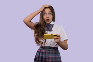 Surprised girl holding yellow smartphone, looking shocked.