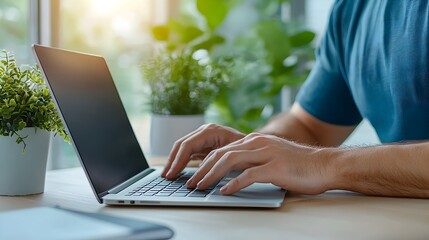 Naklejka premium Freelance professional typing on laptop in a quiet minimalist coworking space with natural lighting and greenery creating a productive and inspiring work environment