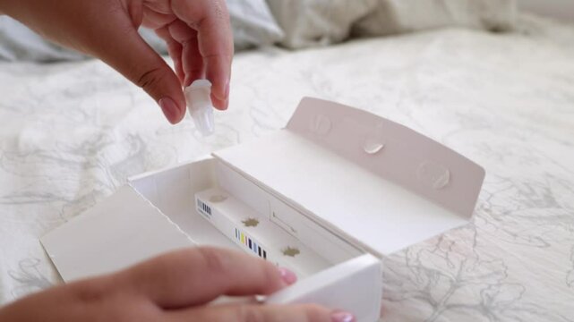 A young woman takes a needle from a box and open the package