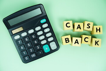 Cashback alphabet letters with calculator top view on green background