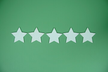 Five Star top view on green background, customer rating and feedback concept