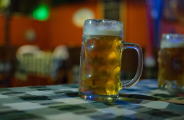  A glass of beer on wooden table. Nice soft background.