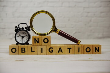 No Obligation with wooden blocks alphabet letters and magnifying glass on wooden background