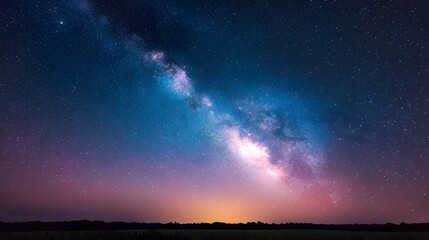 Fototapeta premium A breathtaking view of the Milky Way galaxy illuminating the night sky, surrounded by twinkling stars and a soft gradient horizon.