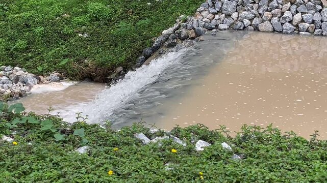 Flow of storm water runoff flowing through two concrete drainage culvert sideway road, stock footage
