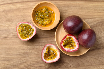 Passion fruit and juice in bowl on wooden background, Tropical fruit, Table top view