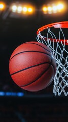 Fototapeta premium Basketball ball passing through hoop, dramatic lighting effect.