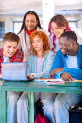 A group of students with laptops sit near the campus and communicate.Vertical