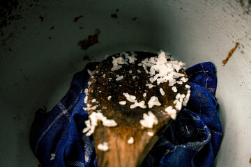 A wooden rice ladle with rice still attached
