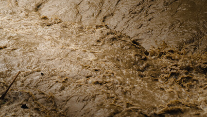 The fast-flowing river water is murky.