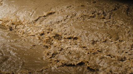 The fast-flowing river water is murky.