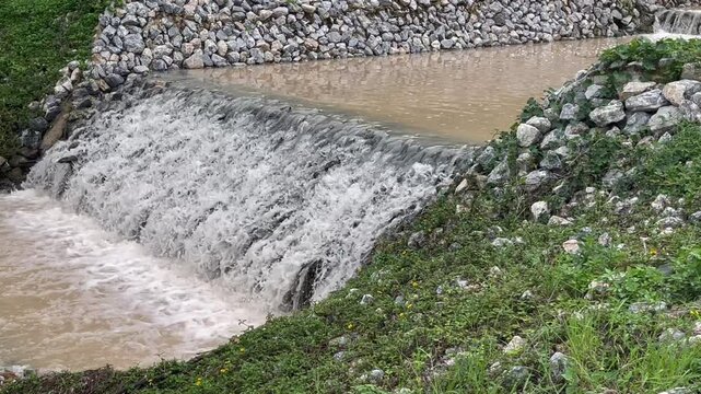 Flow of storm water runoff flowing through two concrete drainage culvert sideway road, stock footage