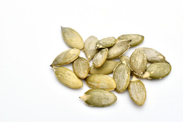 Peeled pumpkin seeds on a white background.