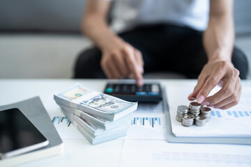 Fototapeta premium Saving money. Man calculate finances home pay bills taxes savings economy financial at home and saving money stacking coins with calculator