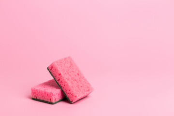 Pink kitchen sponges for washing dishes on a pink background. Homework. Household work. Washing dishes.