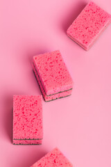 Pink kitchen sponges for washing dishes on a pink background, top view. Homework. Household work. Washing dishes.