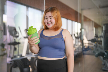 Obese asian woman dieting Weight loss in sportswear drink healthy drink. Sporty asian fat female drinking green Healthy juice After Exercise wellness health